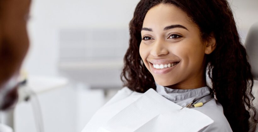 How to prevent enamel loss - woman smiling at dental checkup - Midland Bay Dental.