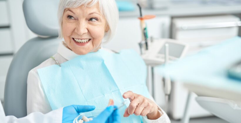 Older woman smiling while sitting in a dental office - CDCP program renewal tips from Midland Bay Dental.