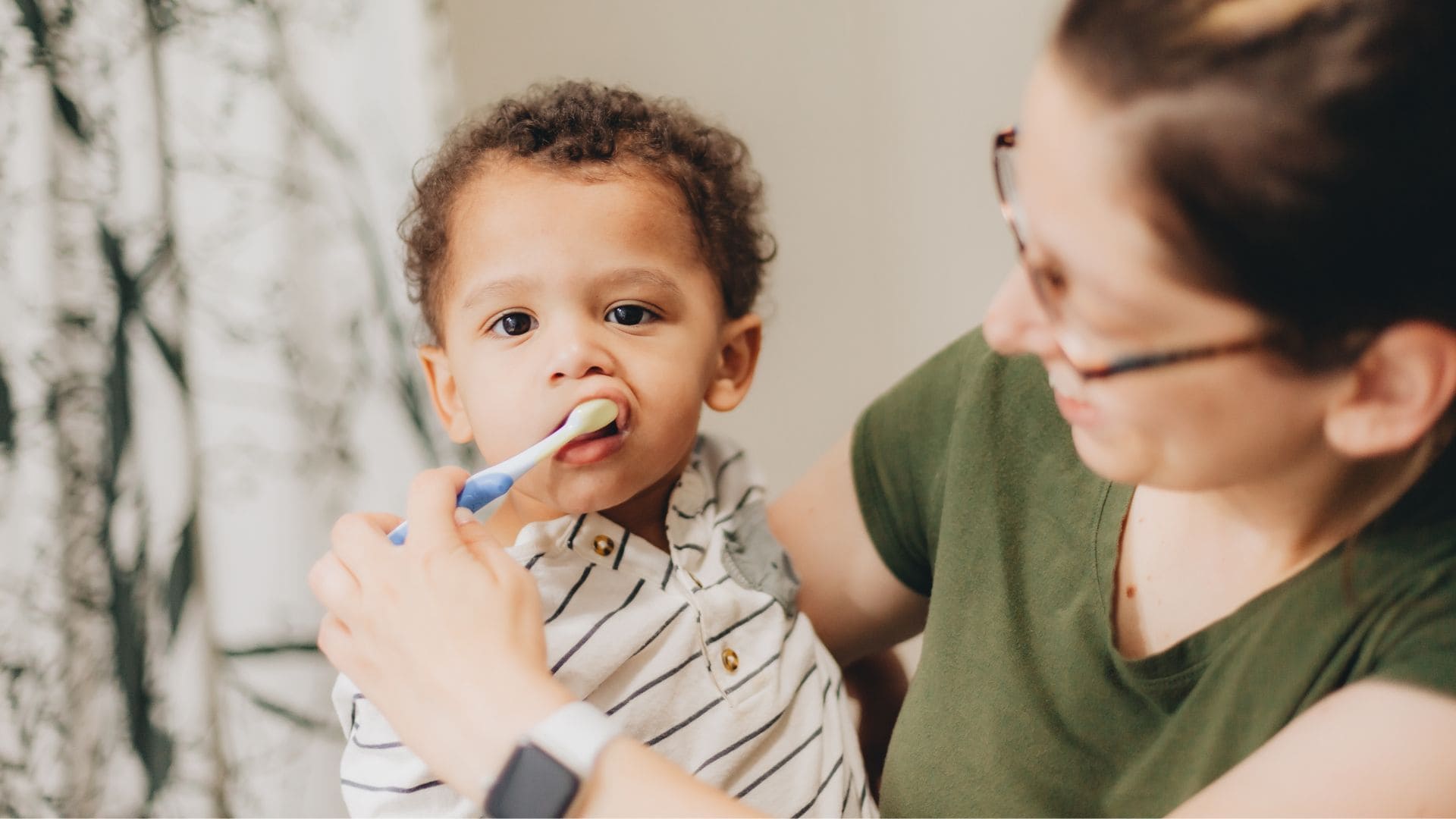 Mom brushing child's teeth - when to make the first dental appointment - Midland Bay Dental.