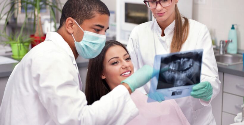 Patient with dentist and hygenist being shown xrays - how long do dental crowns last - Midland Bay Dental.
