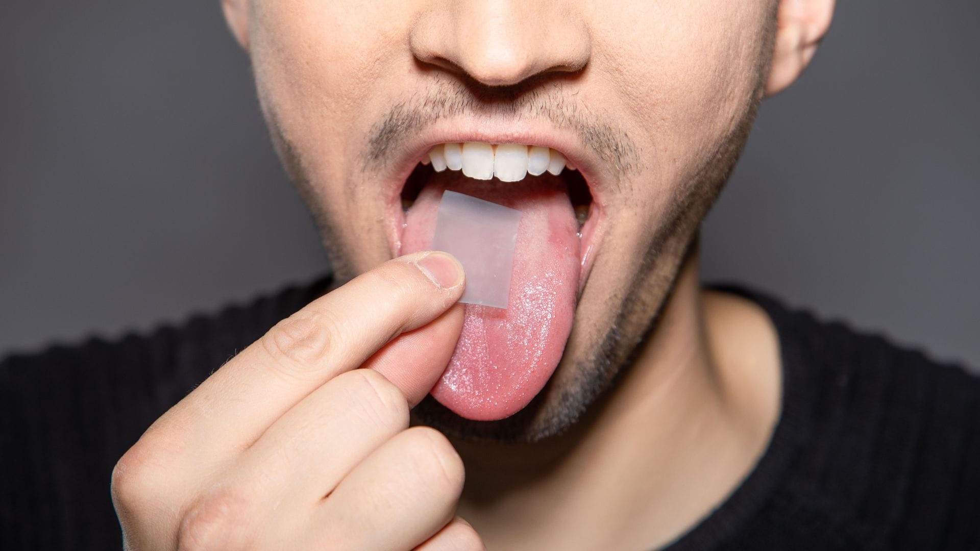 Man placing a lozenge on tongue - dry mouth at night.